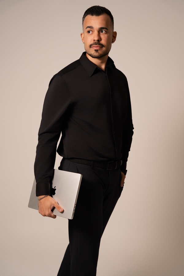 Ricardo Bonizoli, de camisa preta, segurando um notebook